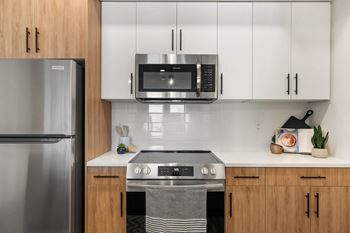 a modern kitchen with stainless steel appliances and white cabinets
